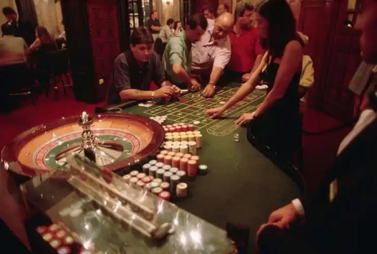 Roulette wheel and blackjack table displayed on mobile screen with betting interface